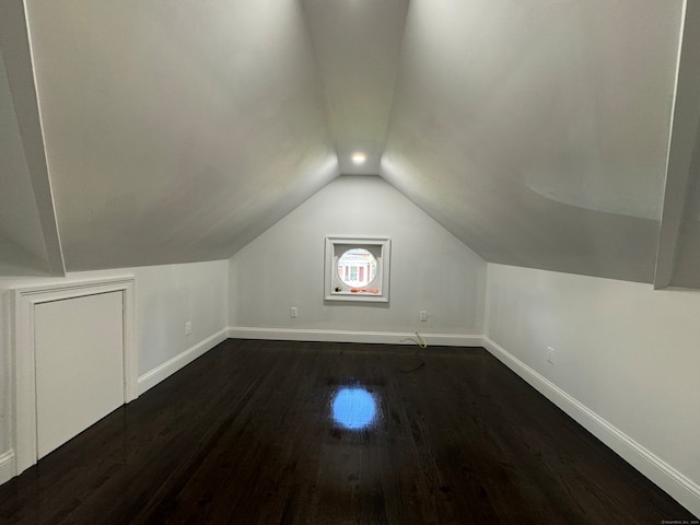 additional living space with dark hardwood / wood-style floors and lofted ceiling