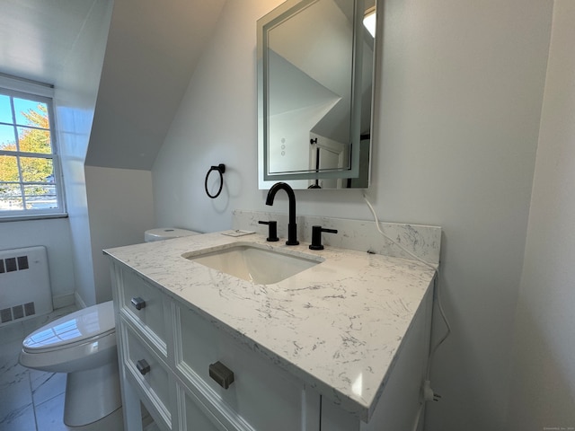 bathroom with vanity, toilet, and radiator