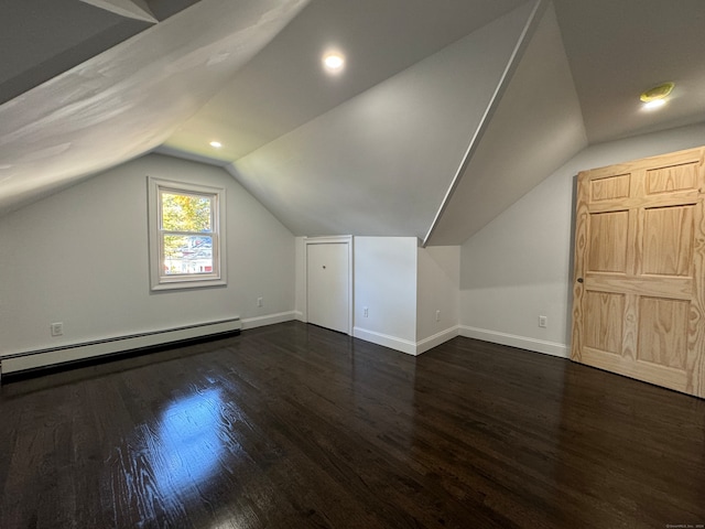 additional living space featuring dark hardwood / wood-style flooring, vaulted ceiling, and baseboard heating