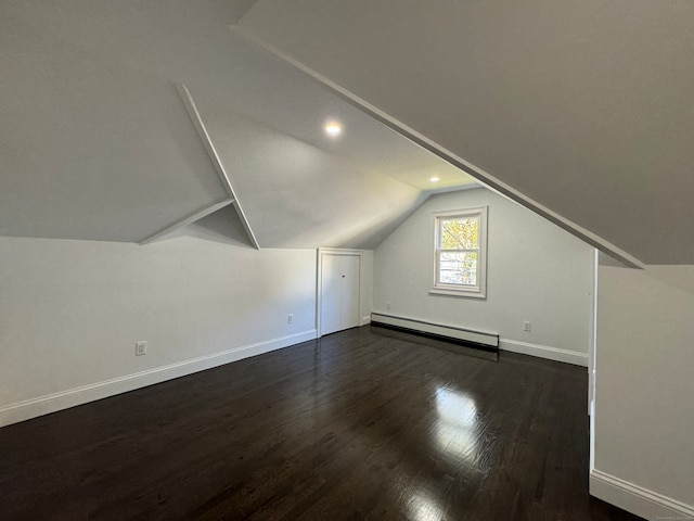 bonus room with dark hardwood / wood-style flooring, lofted ceiling, and a baseboard heating unit