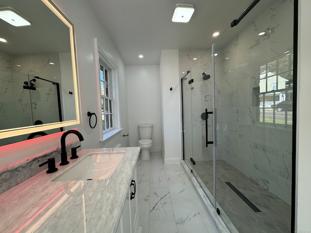 bathroom with a shower with door, vanity, and toilet