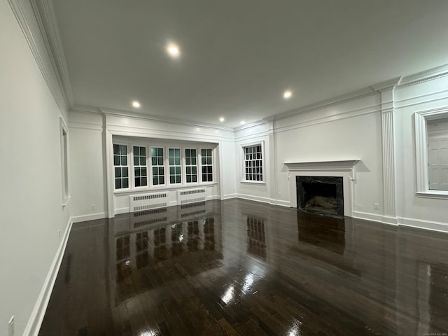 unfurnished living room with radiator, a fireplace, dark hardwood / wood-style floors, and ornamental molding