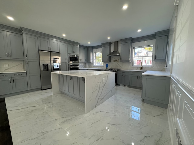 kitchen with gray cabinets, wall chimney exhaust hood, and stainless steel appliances