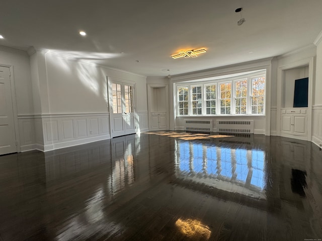 spare room featuring dark hardwood / wood-style flooring, ornamental molding, and radiator heating unit