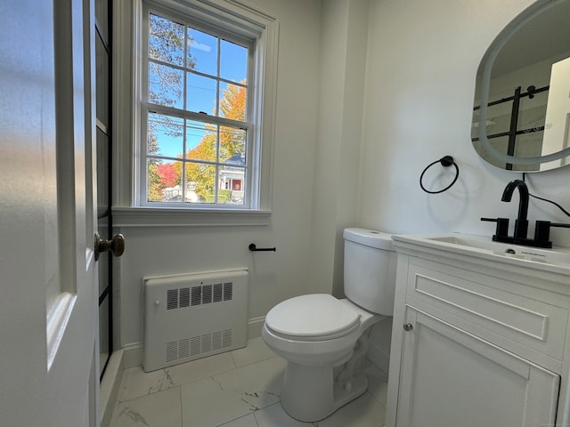 bathroom with radiator, vanity, and toilet