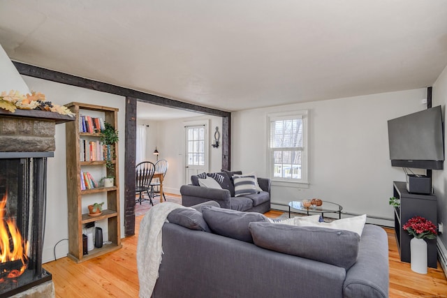 living room with a baseboard heating unit and light wood-type flooring