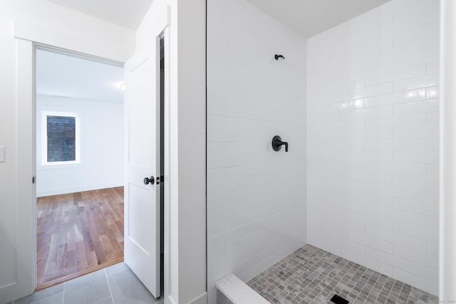 bathroom with tile patterned flooring and a tile shower