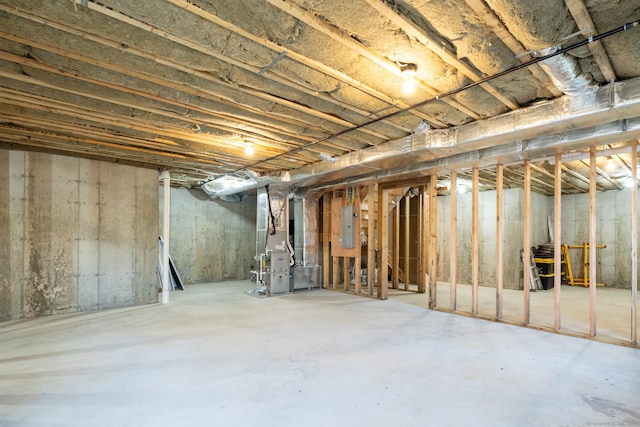 basement featuring electric panel and heating unit