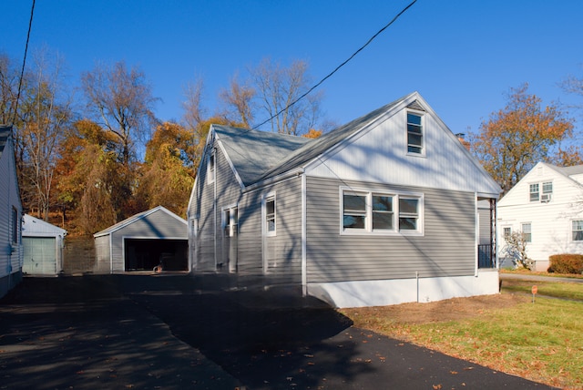 view of home's exterior with a garage and an outdoor structure