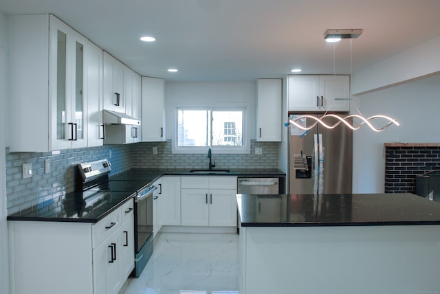 kitchen with decorative backsplash, white cabinetry, sink, and stainless steel appliances