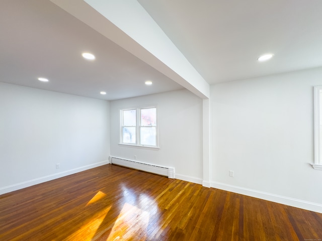 spare room featuring dark hardwood / wood-style floors and a baseboard heating unit