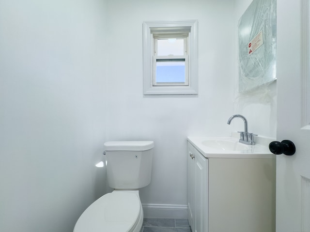 bathroom with tile patterned flooring, vanity, and toilet