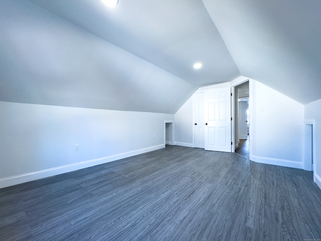 additional living space featuring dark hardwood / wood-style floors and lofted ceiling