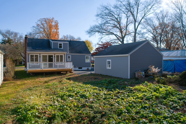 rear view of house with a wooden deck and a yard