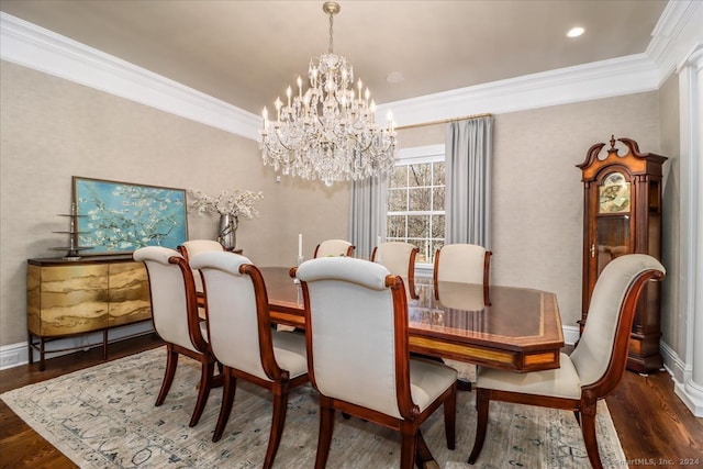 dining room featuring dark hardwood / wood-style flooring, an inviting chandelier, and ornamental molding