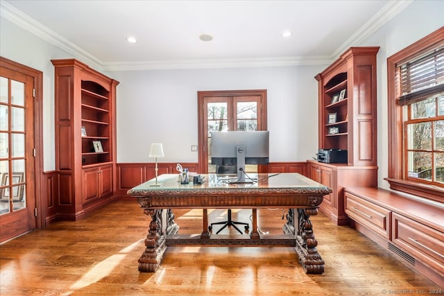 home office with plenty of natural light, hardwood / wood-style floors, and ornamental molding