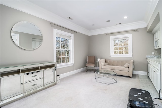 living area with crown molding and light colored carpet