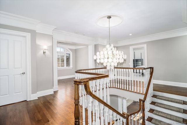 staircase featuring hardwood / wood-style floors, crown molding, and a chandelier