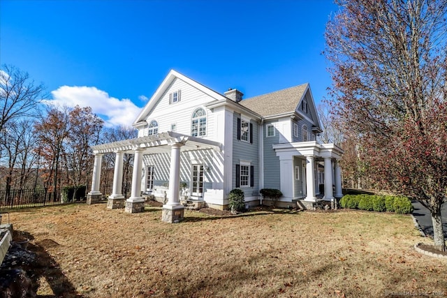 view of home's exterior with a pergola and a lawn