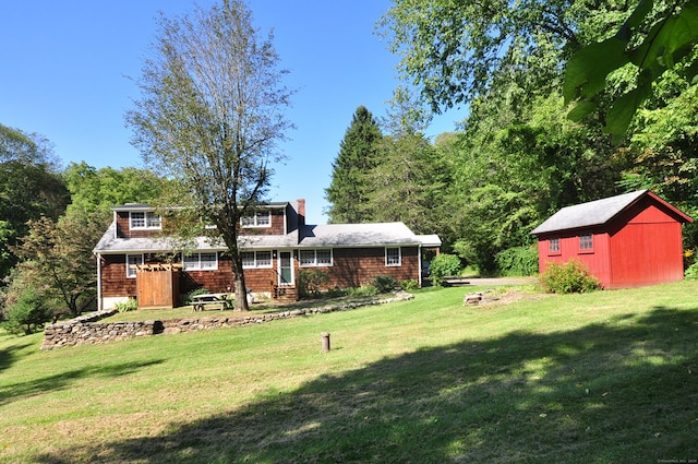 view of front facade featuring a front yard and a shed