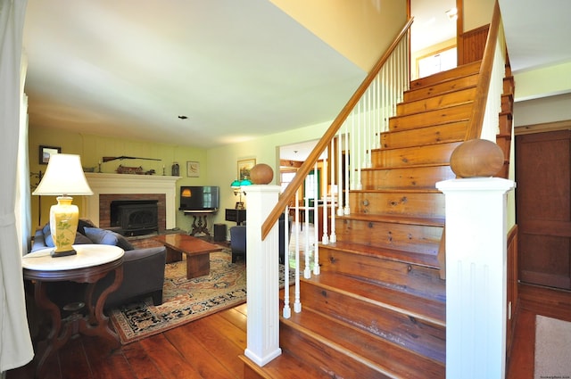 staircase featuring a wood stove and hardwood / wood-style flooring