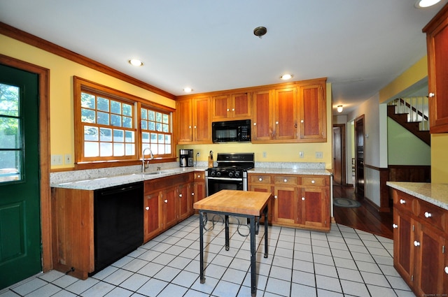 kitchen with light stone countertops, ornamental molding, sink, black appliances, and light tile patterned floors