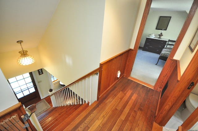 stairway with hardwood / wood-style flooring and wooden walls