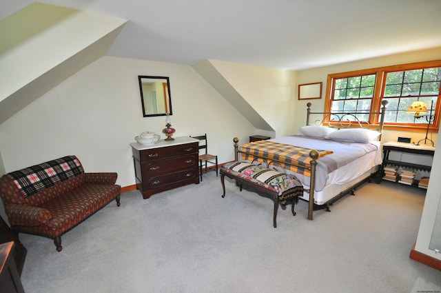 bedroom featuring light colored carpet and vaulted ceiling