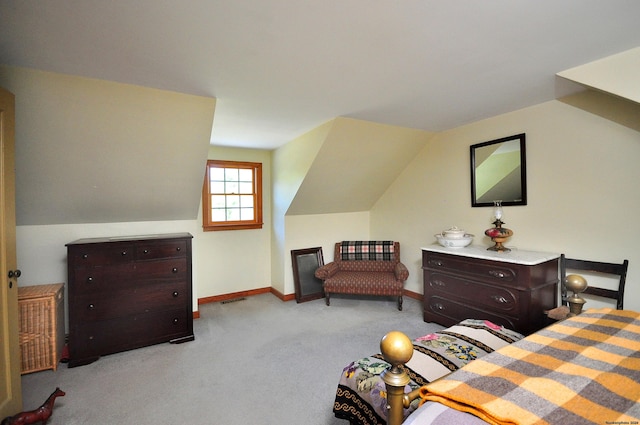 bedroom with light colored carpet and lofted ceiling