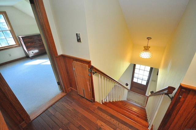 staircase featuring hardwood / wood-style floors and lofted ceiling