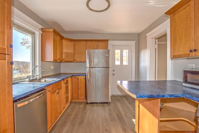 kitchen with appliances with stainless steel finishes, light wood-type flooring, and sink