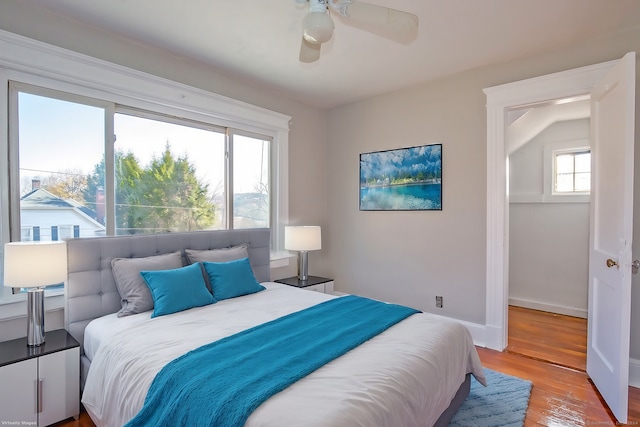 bedroom with ceiling fan, lofted ceiling, light hardwood / wood-style flooring, and multiple windows