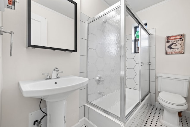 full bathroom featuring sink, tile patterned flooring, crown molding, combined bath / shower with glass door, and toilet