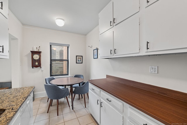 kitchen featuring light tile patterned floors, white dishwasher, white cabinetry, and crown molding