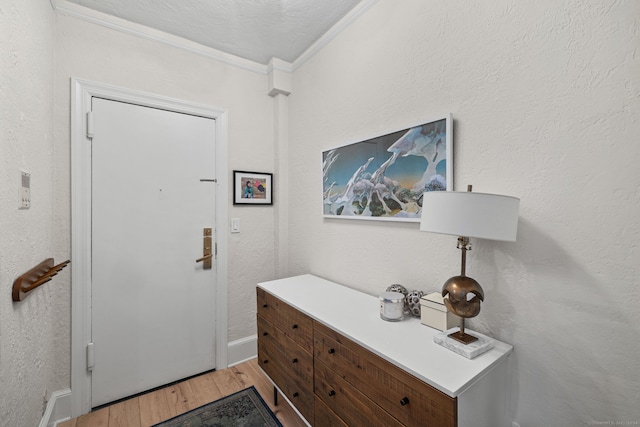 entryway with a textured ceiling, hardwood / wood-style flooring, and crown molding