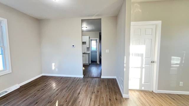 unfurnished room with hardwood / wood-style floors and a healthy amount of sunlight