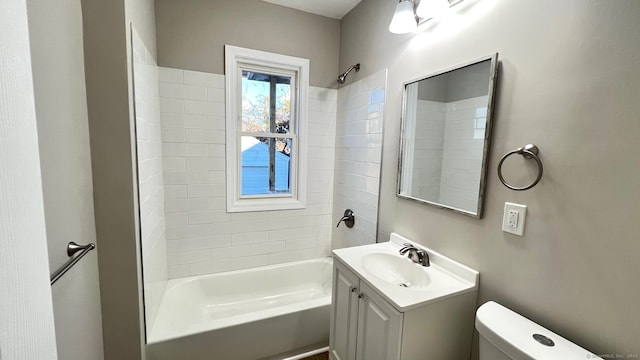 full bathroom with tiled shower / bath, vanity, and toilet