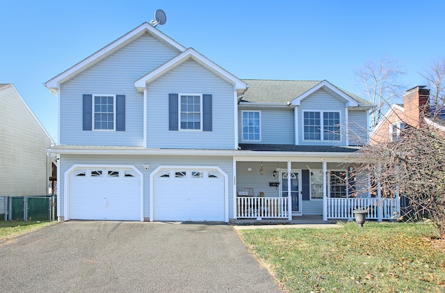 view of front of house with covered porch, a garage, and a front yard