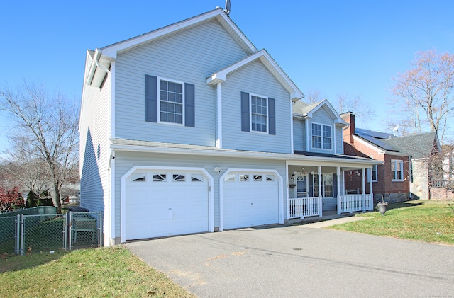 view of front of house with a porch, a garage, and a front lawn