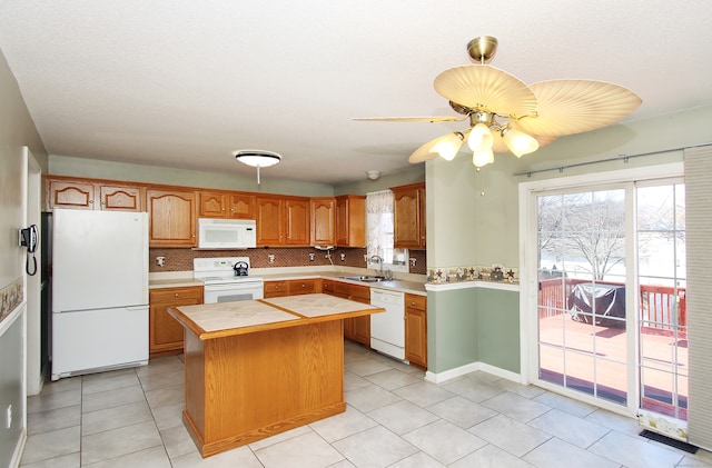 kitchen with tasteful backsplash, white appliances, ceiling fan, sink, and a kitchen island