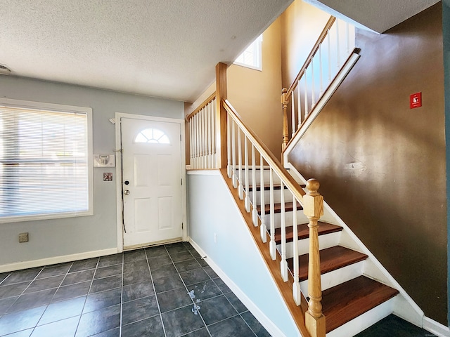 tiled entryway with a textured ceiling