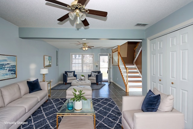 tiled living room featuring ceiling fan and a textured ceiling