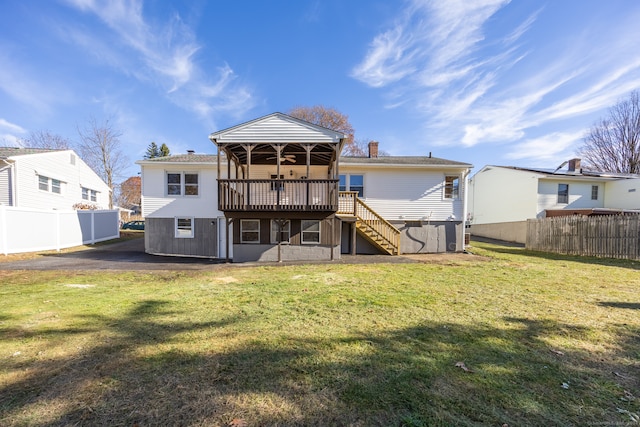 back of house featuring a lawn and a deck