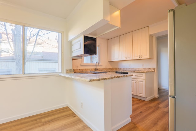 kitchen featuring crown molding, white cabinets, and light wood-type flooring