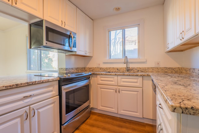 kitchen with a sink, appliances with stainless steel finishes, and white cabinets