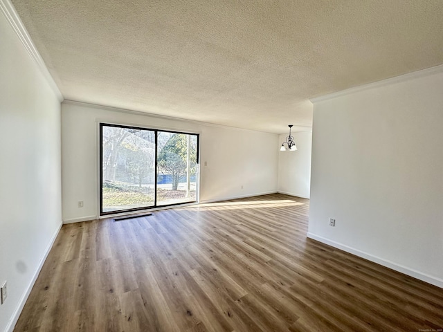 unfurnished room featuring crown molding, wood finished floors, and a textured ceiling