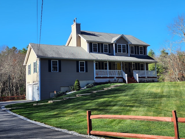 view of front of house featuring covered porch, a front yard, and a garage