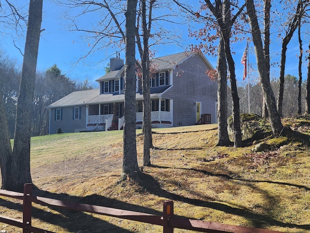 view of front of home with covered porch and a front lawn