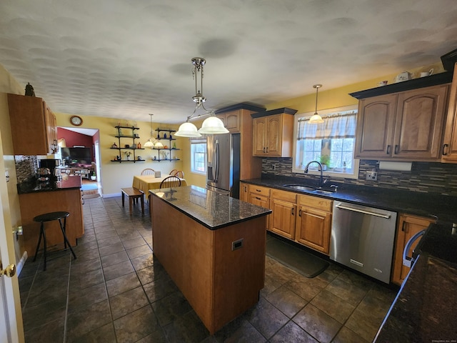 kitchen featuring sink, a center island, hanging light fixtures, stainless steel appliances, and backsplash