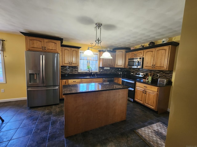 kitchen featuring sink, appliances with stainless steel finishes, a kitchen island, pendant lighting, and backsplash